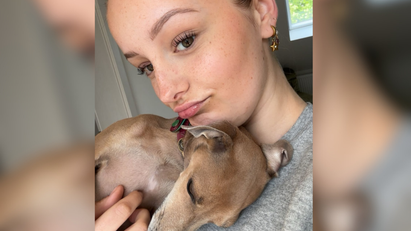 Eine Frau, die einen Hund im Arm hält