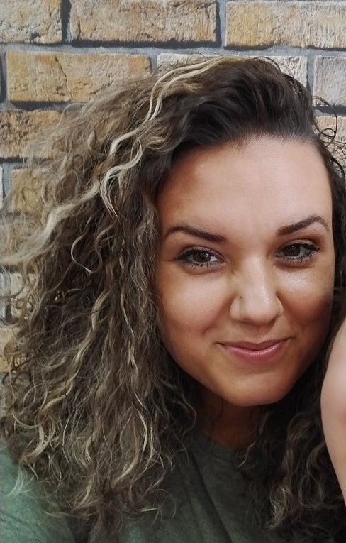 Eine Frau mit lockigem Haar lächelt