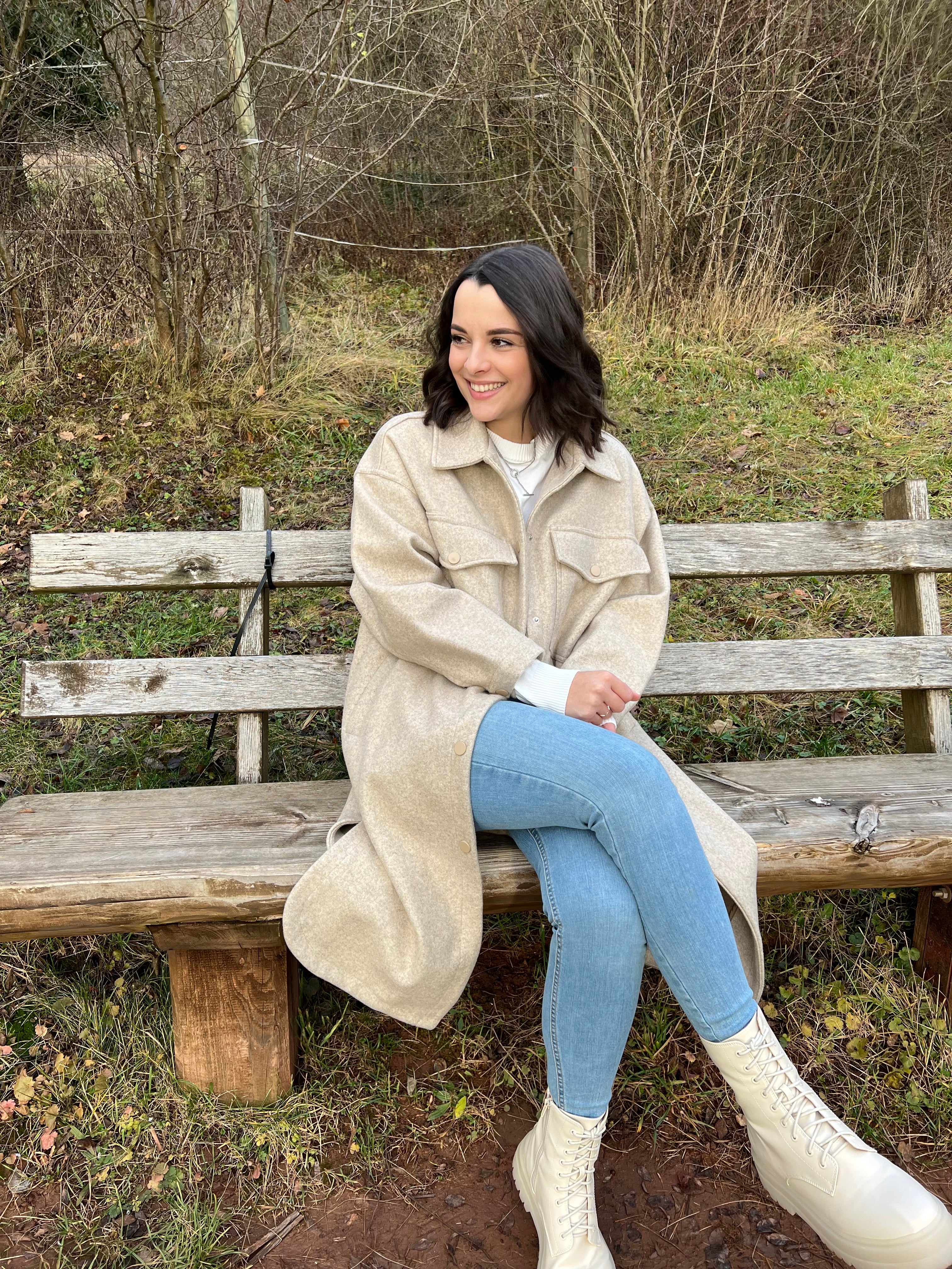 Janina hat sich zurückgekämpft ins Leben, sie sitzt auf einer Bank und lächelt 