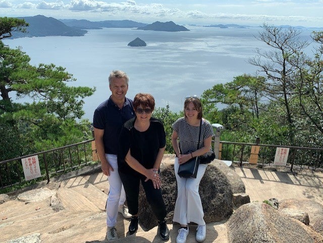 Robert und seine Familie an einem Aussichtspunkt. Hinter ihnen ist das Meer zu sehen.