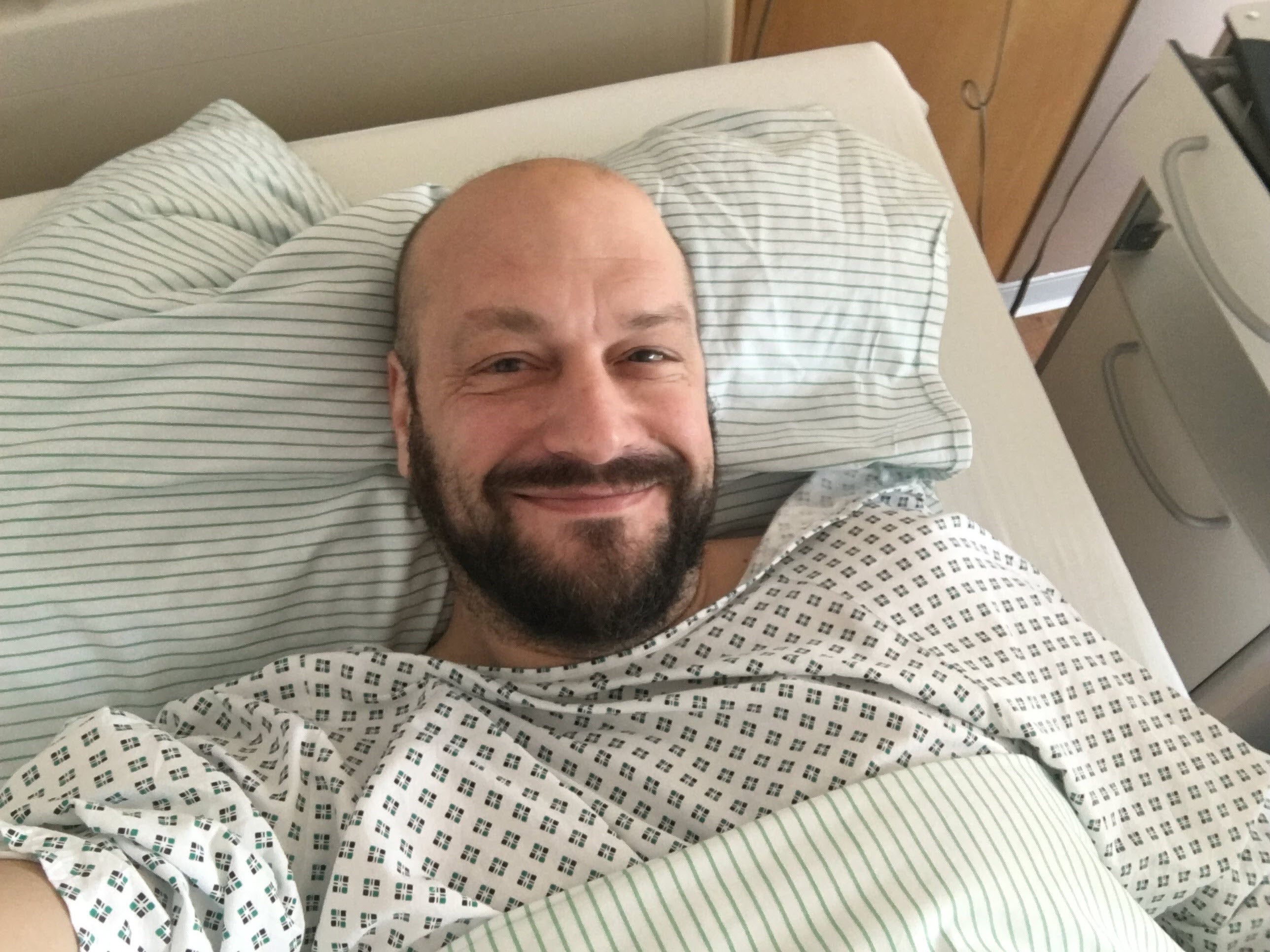 Axel bei seiner Stammzellspende, er liegt in einem Krankenhausbett und macht ein Selfie