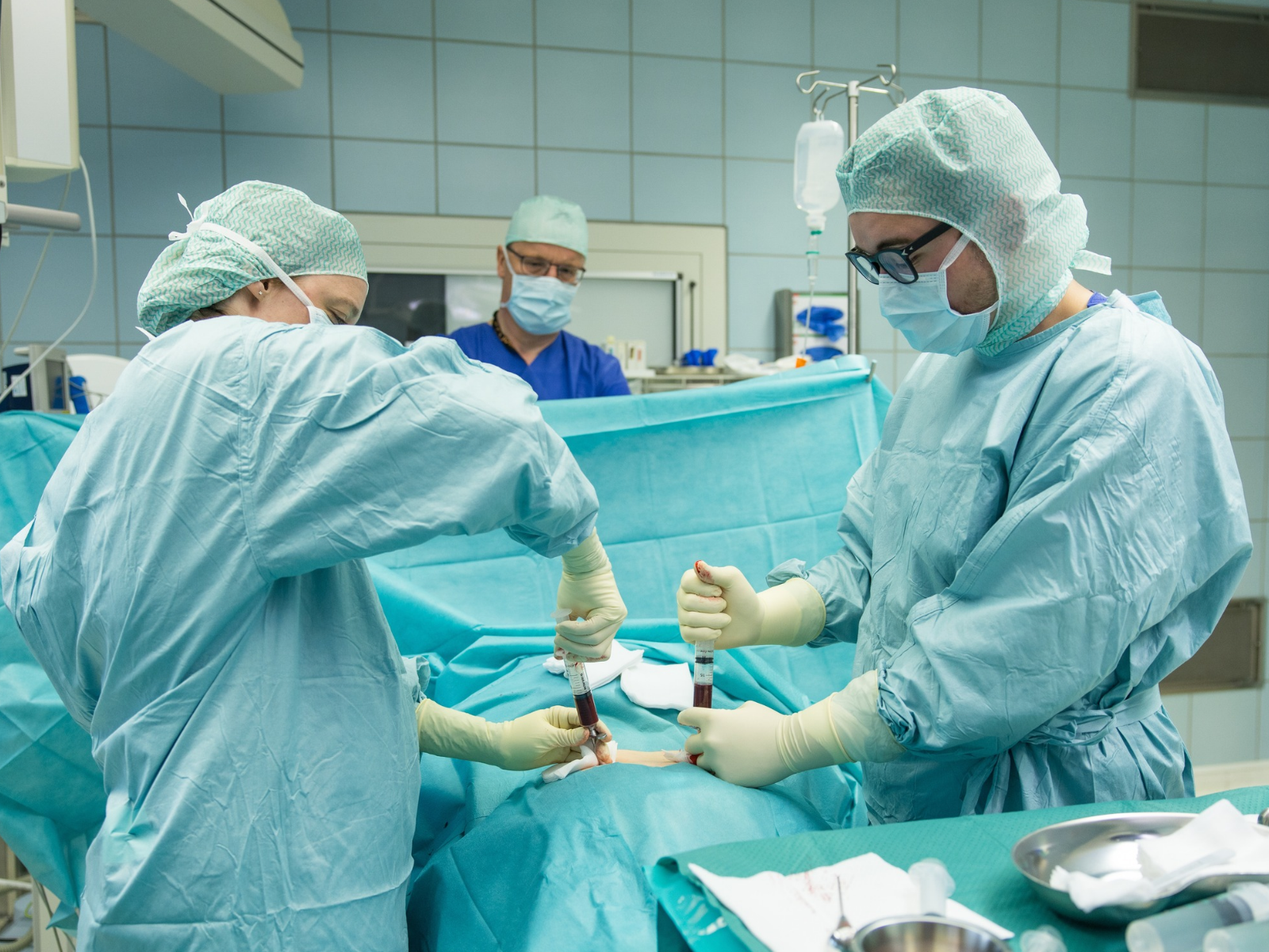 Ärzte entnehmen einem Patienten in einem OP-Raum Knochenmark