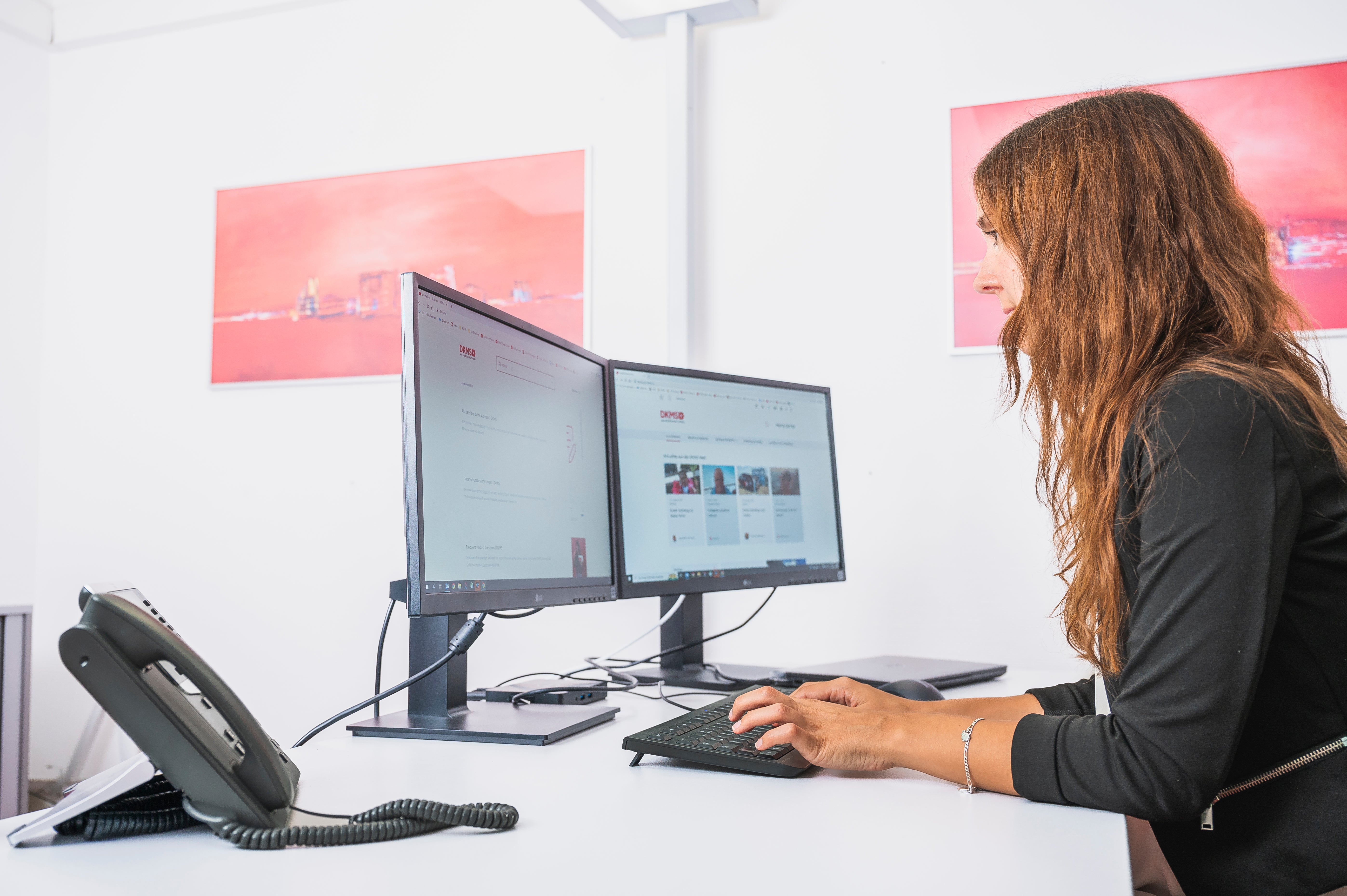 Eine Frau sitzt an einem Schreibtisch und benutzt einen Computer