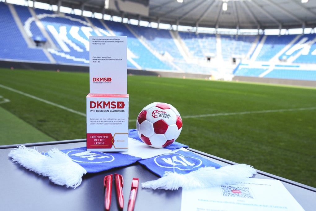 DKMS-Materialien sind vor der Kulisse des Stadions des KSC zu sehen.