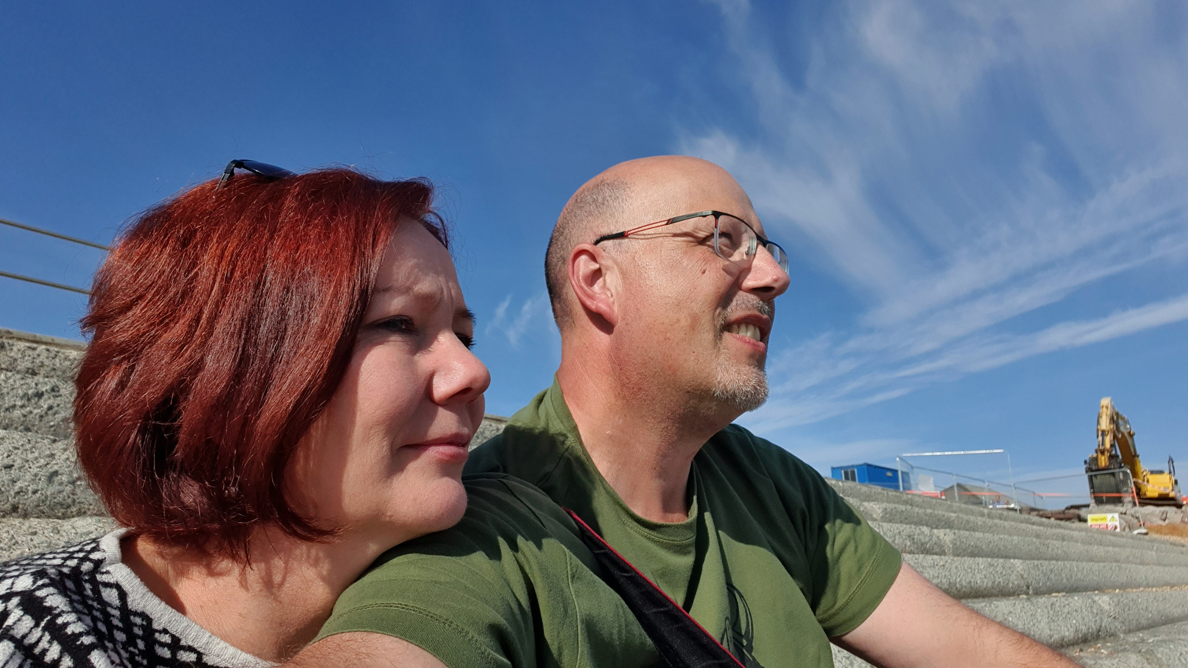 Patientin Yvonne sitz mit ihrem Partner auf  einer Treppe