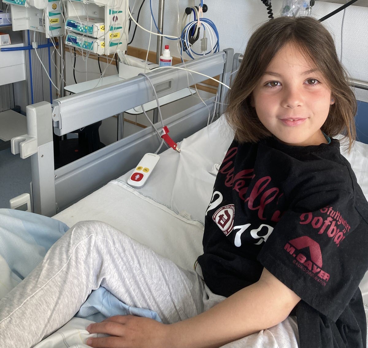 Ein Mädchen sitzt in einem Krankenhausbett