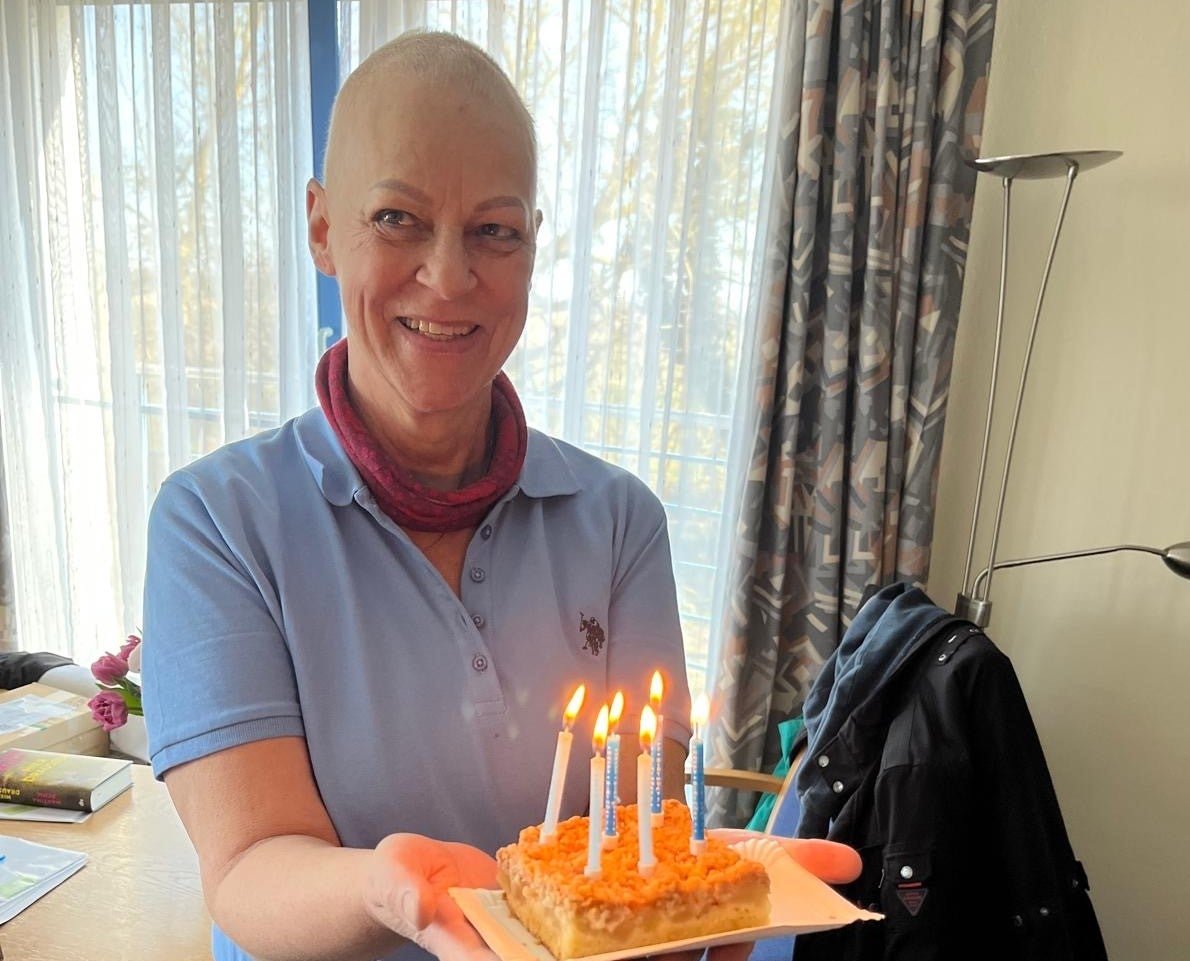 Eine Frau hält einen Kuchen mit Kerzen