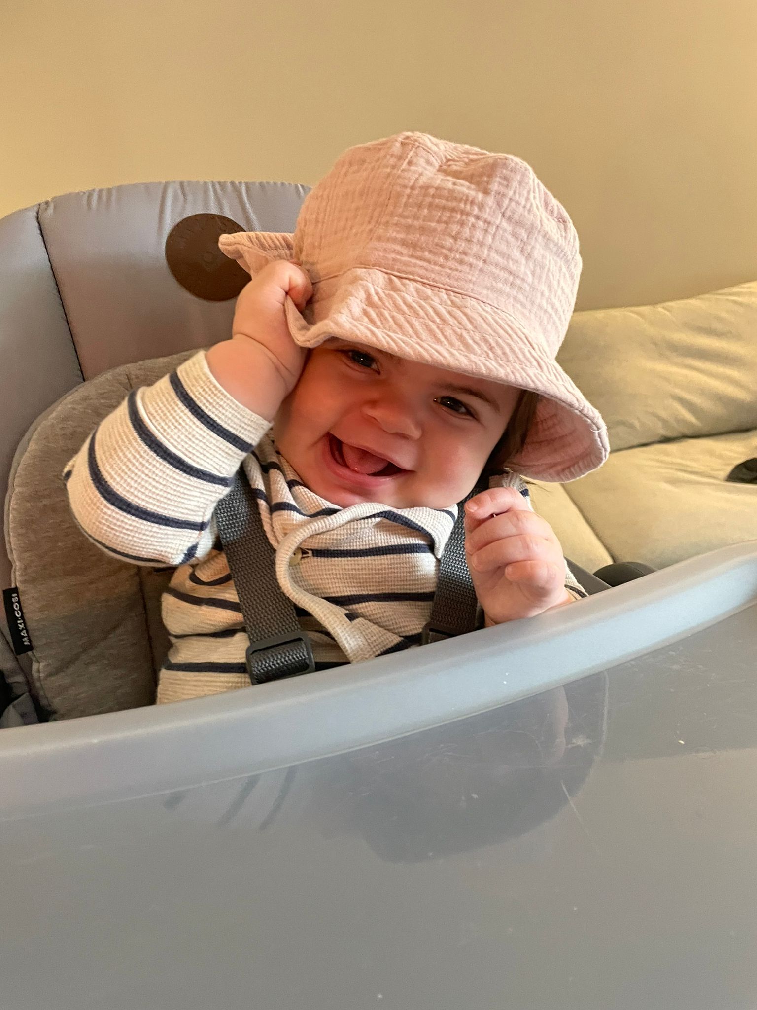 kleines Kind sitzt in einem Hochstuhl und grinst