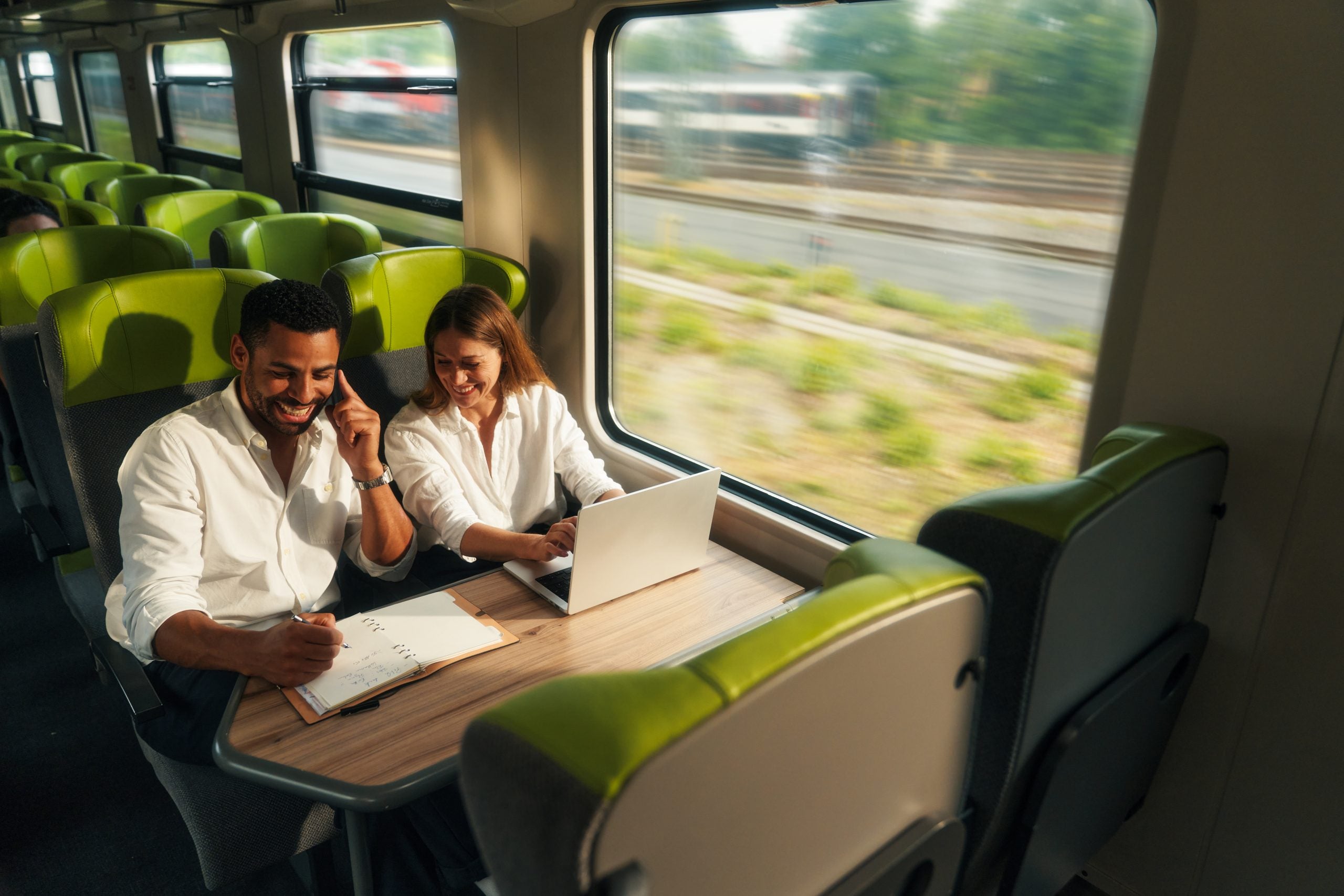 Ein Mann und eine Frau sitzen an einem Tisch mit einem Laptop