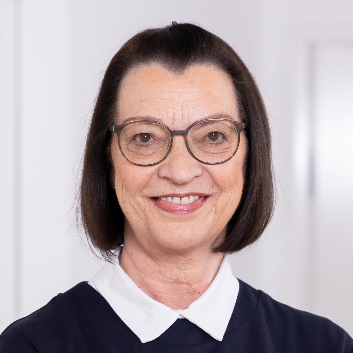 Eine Frau mit kurzen braunen Haaren und Brille