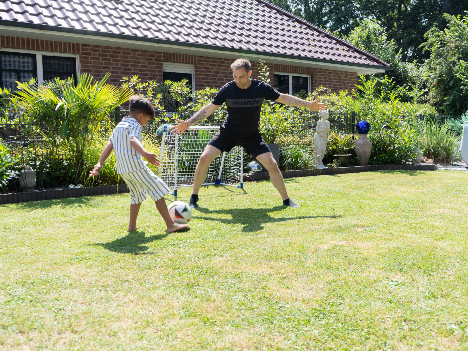 Shahil und Sven spielen im Garten Fußball