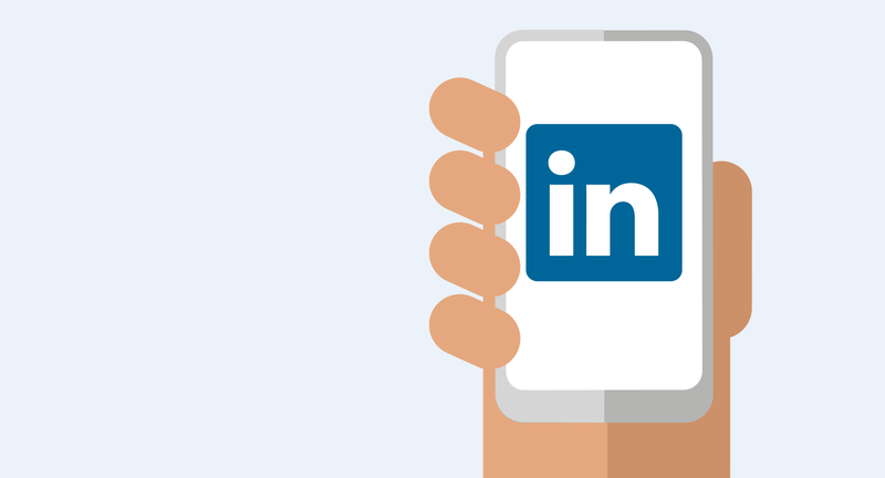 Eine Hand hält ein Handy mit LinkedIn Icon