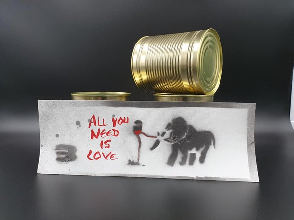 Eine Installation aus Dosen und einem Schild. Auf dem Schild steht "All you need is love"