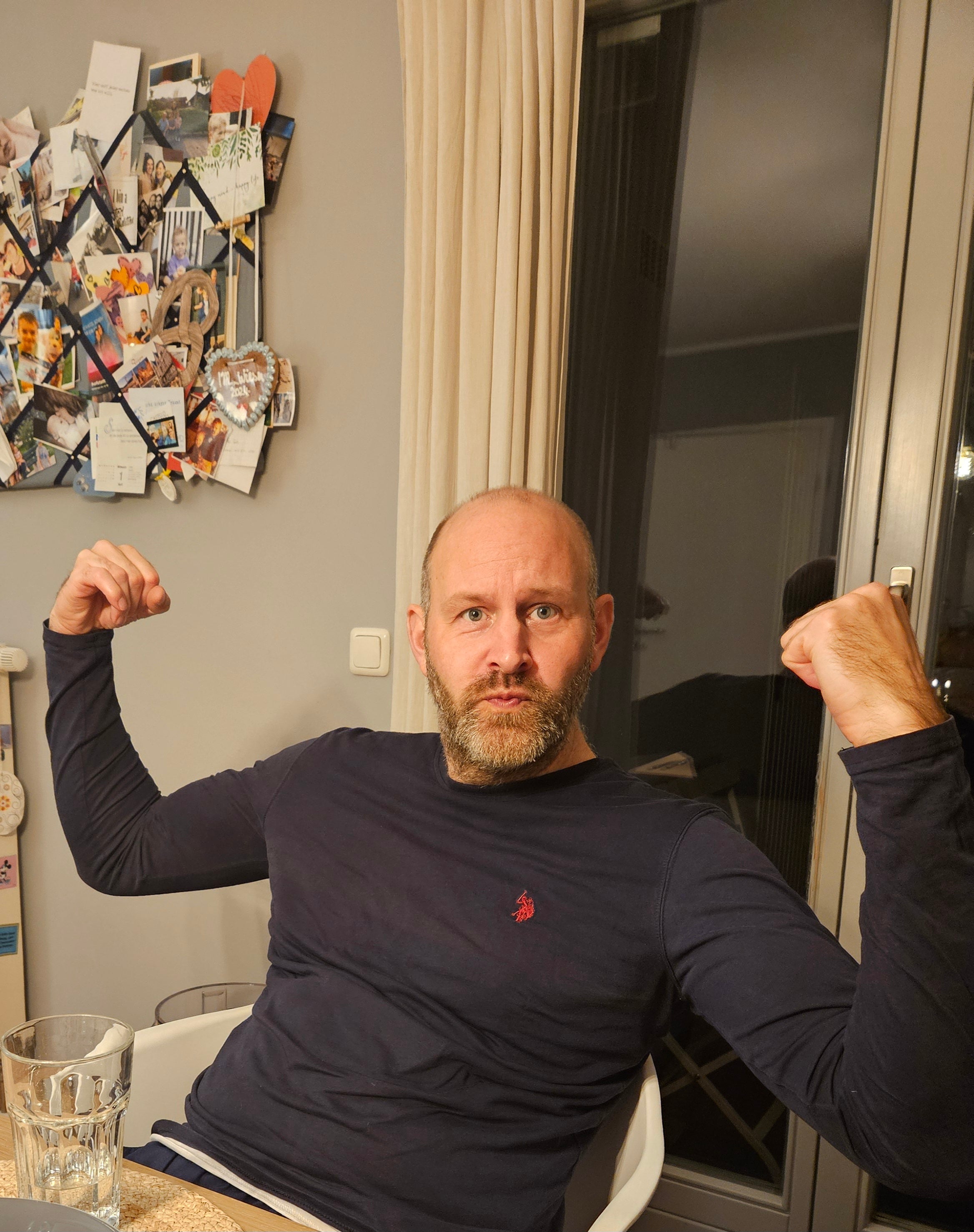 Ein Mann sitzt mit erhobenen Armen auf einem Stuhl