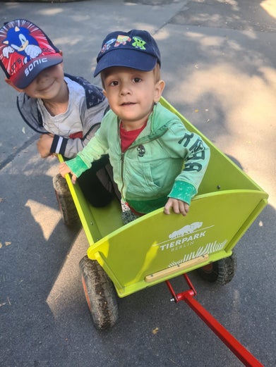 Zu sehen ist Robin im Bobbycar beim Spiel mit seinem Bruder.