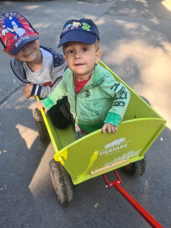 Zu sehen ist Robin im Bobbycar beim Spiel mit seinem Bruder.