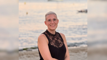 Eine Frau, die in die Kamera lächelt