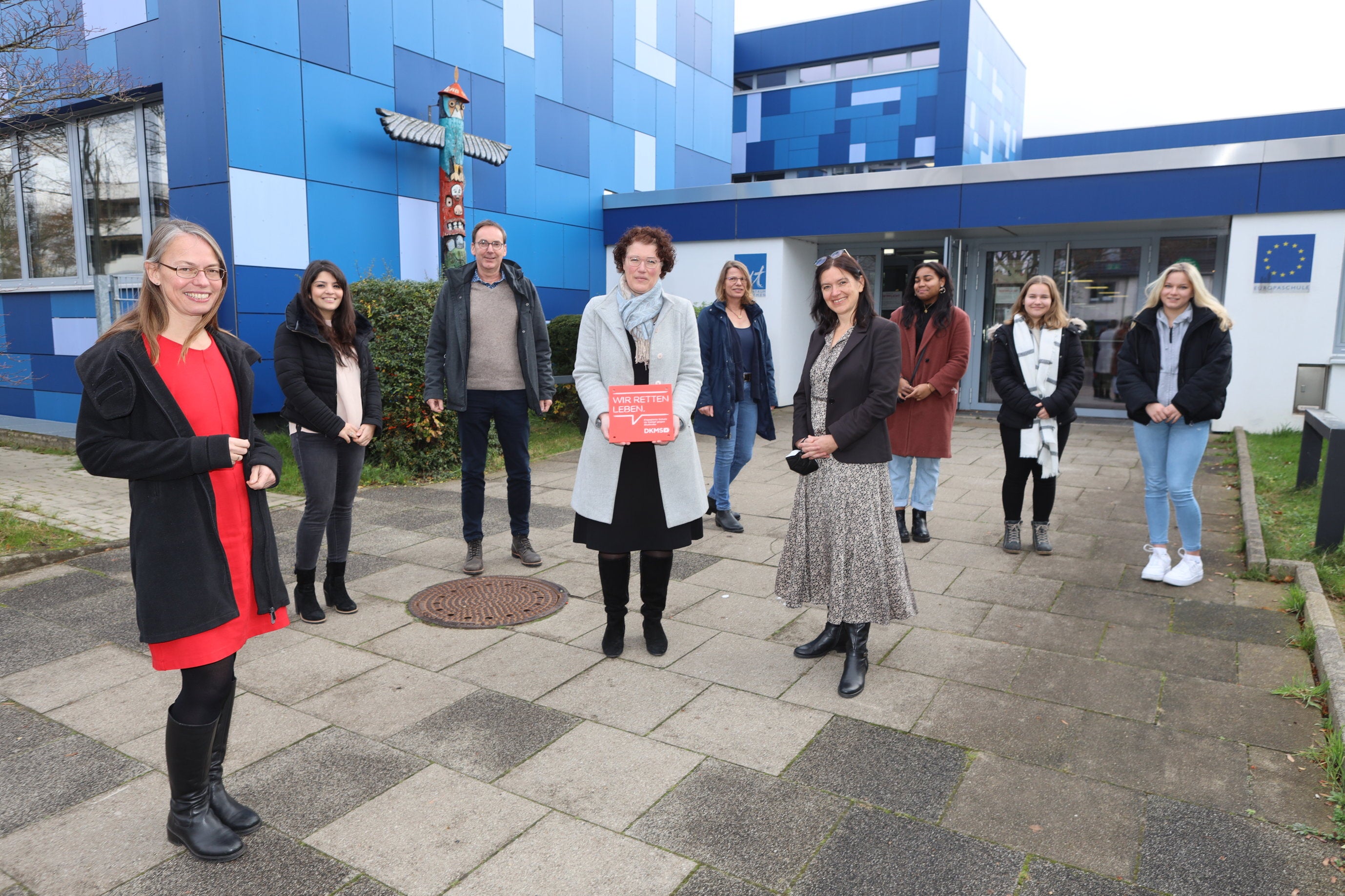 Mehrere Personen halten DKMS Schulsiegel