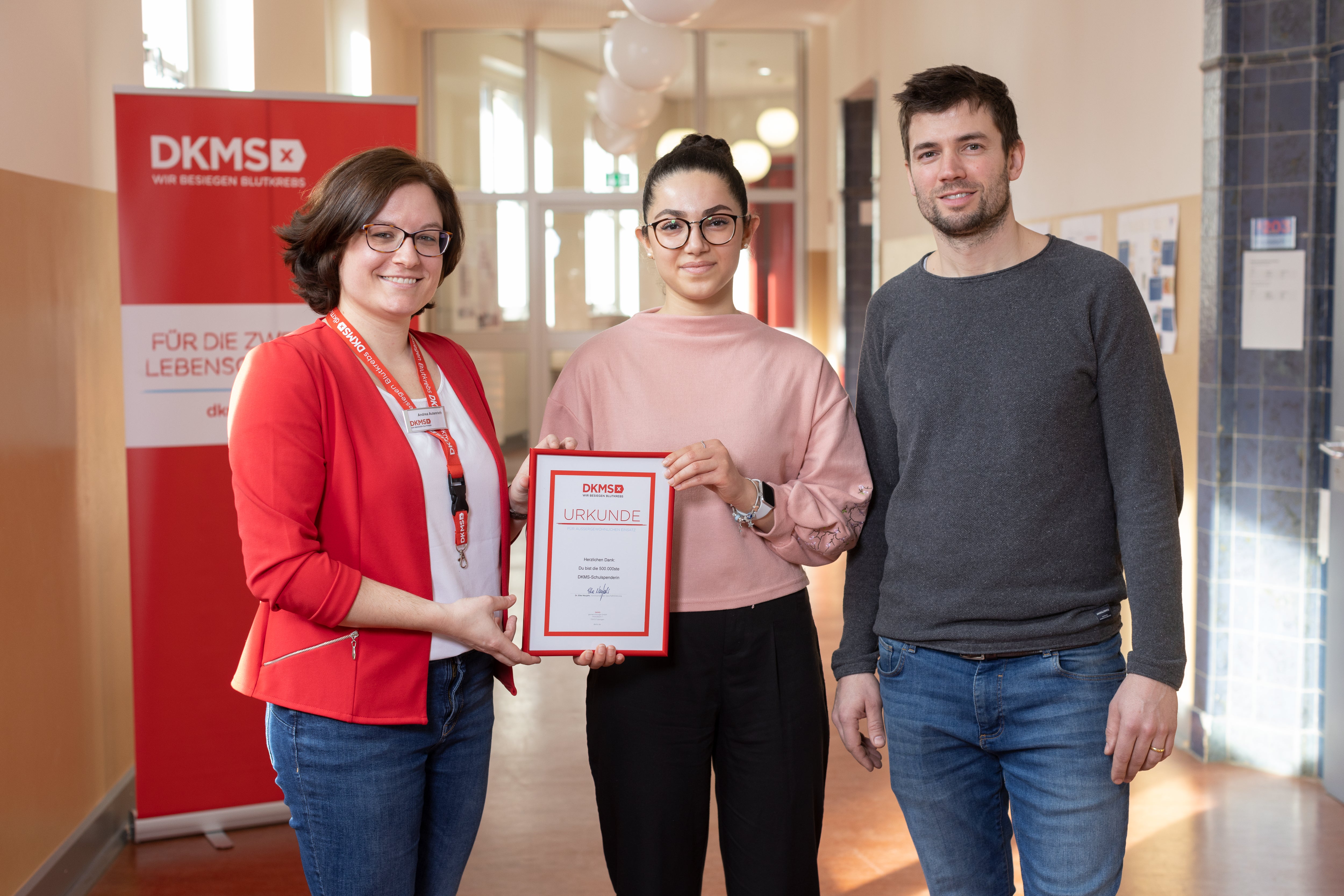 Eine Gruppe von Menschen posiert für ein Foto, sie halten eine Urkunde in der Hand