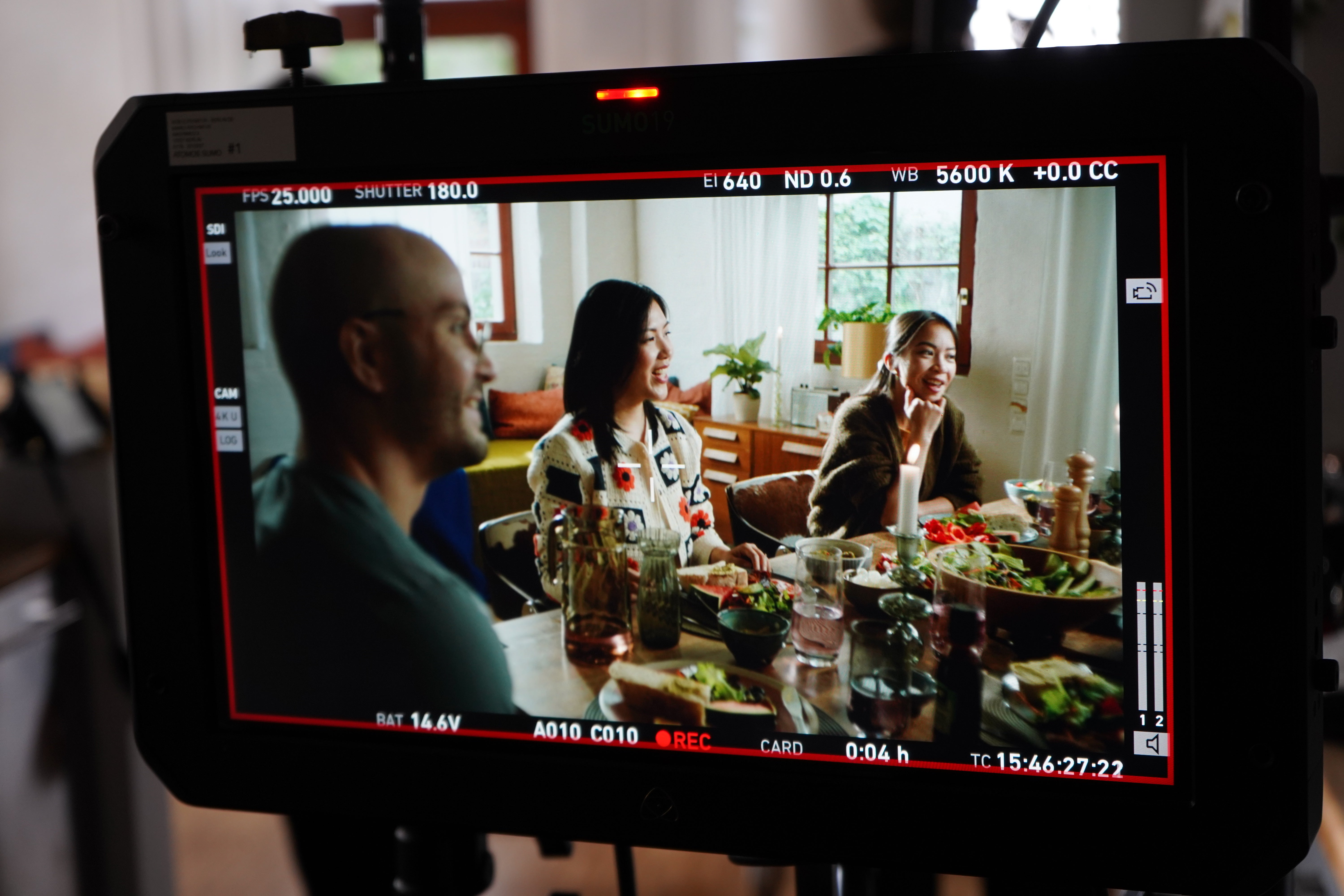 Ein Bildschirm mit einer Gruppe von Menschen, die an einem Tisch sitzen