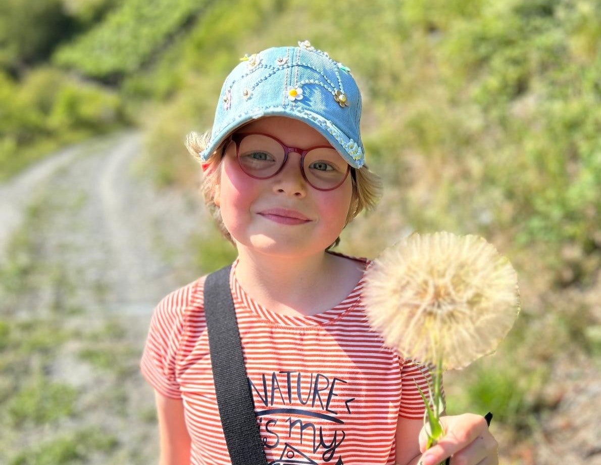Ein Mädchen hält einen Löwenzahn