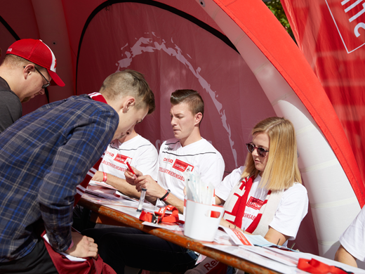 Eine Gruppe von Menschen, die an einem Tisch sitzen bei einer Registrierungsaktion der DKMS