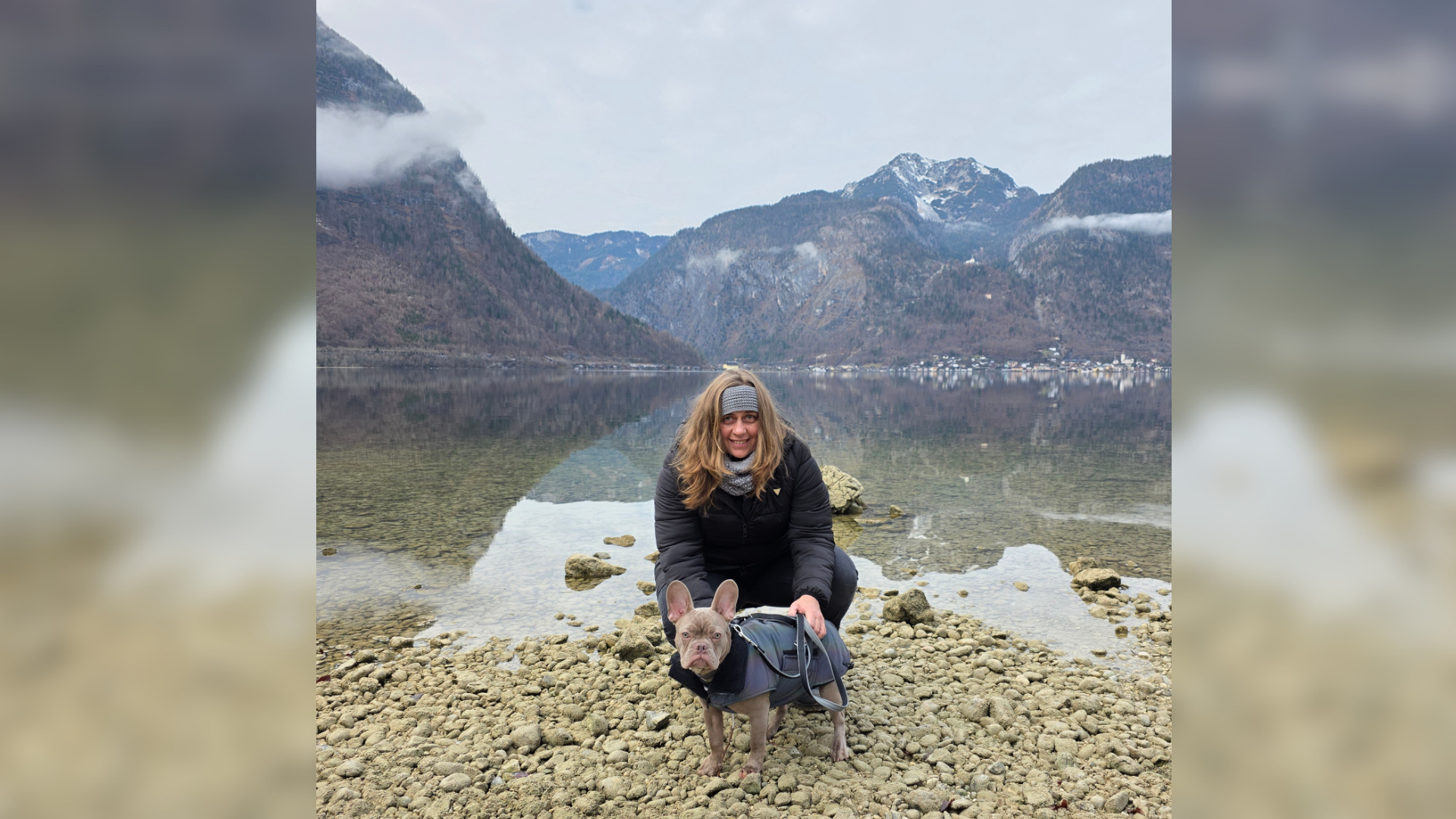 Eine Frau mit einem Hund an einem felsigen Strand