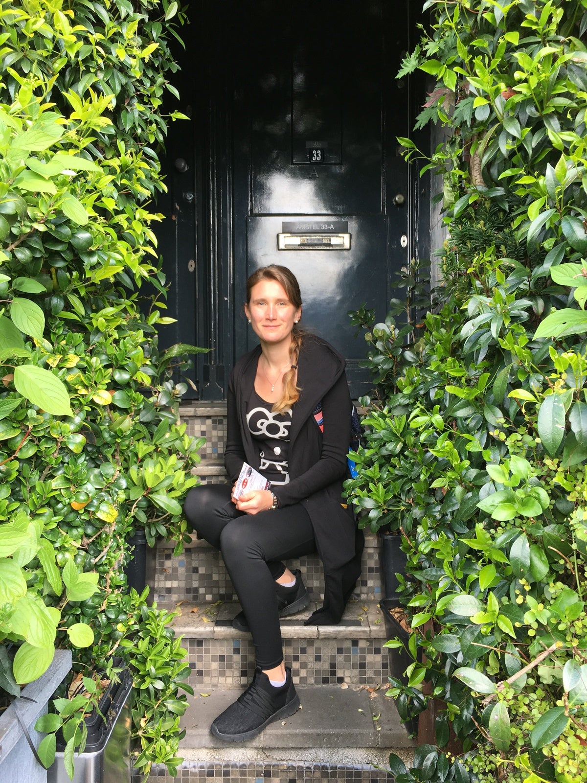 Eine Frau sitzt auf Stufen vor einer Tür