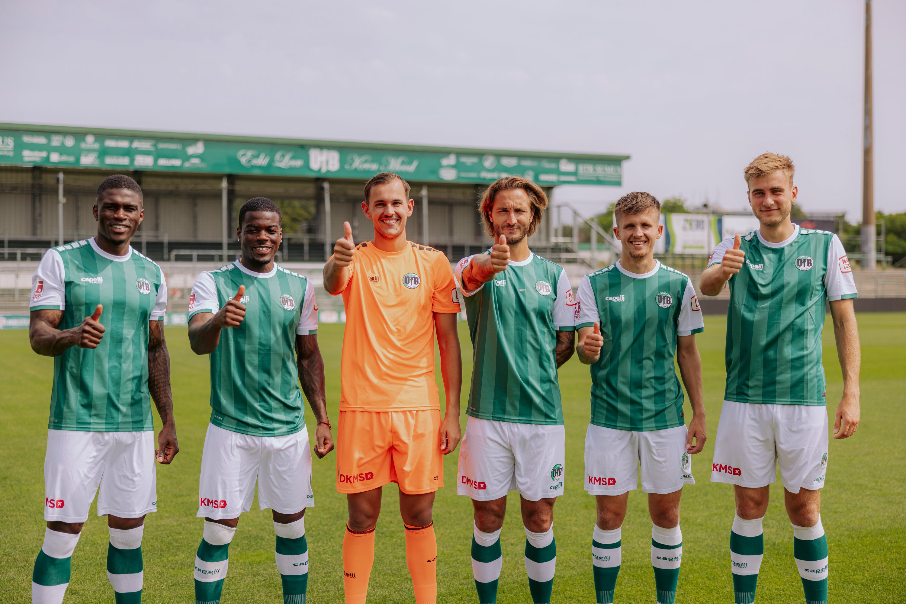 Sechs Spieler des VfB Lübeck mit DKMS-Logo und Daumen hoch © Agentur 54 Grad