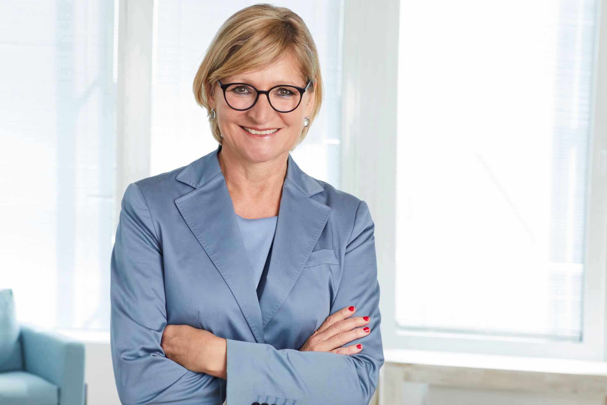 Eine Frau im Anzug mit verschränkten Armen