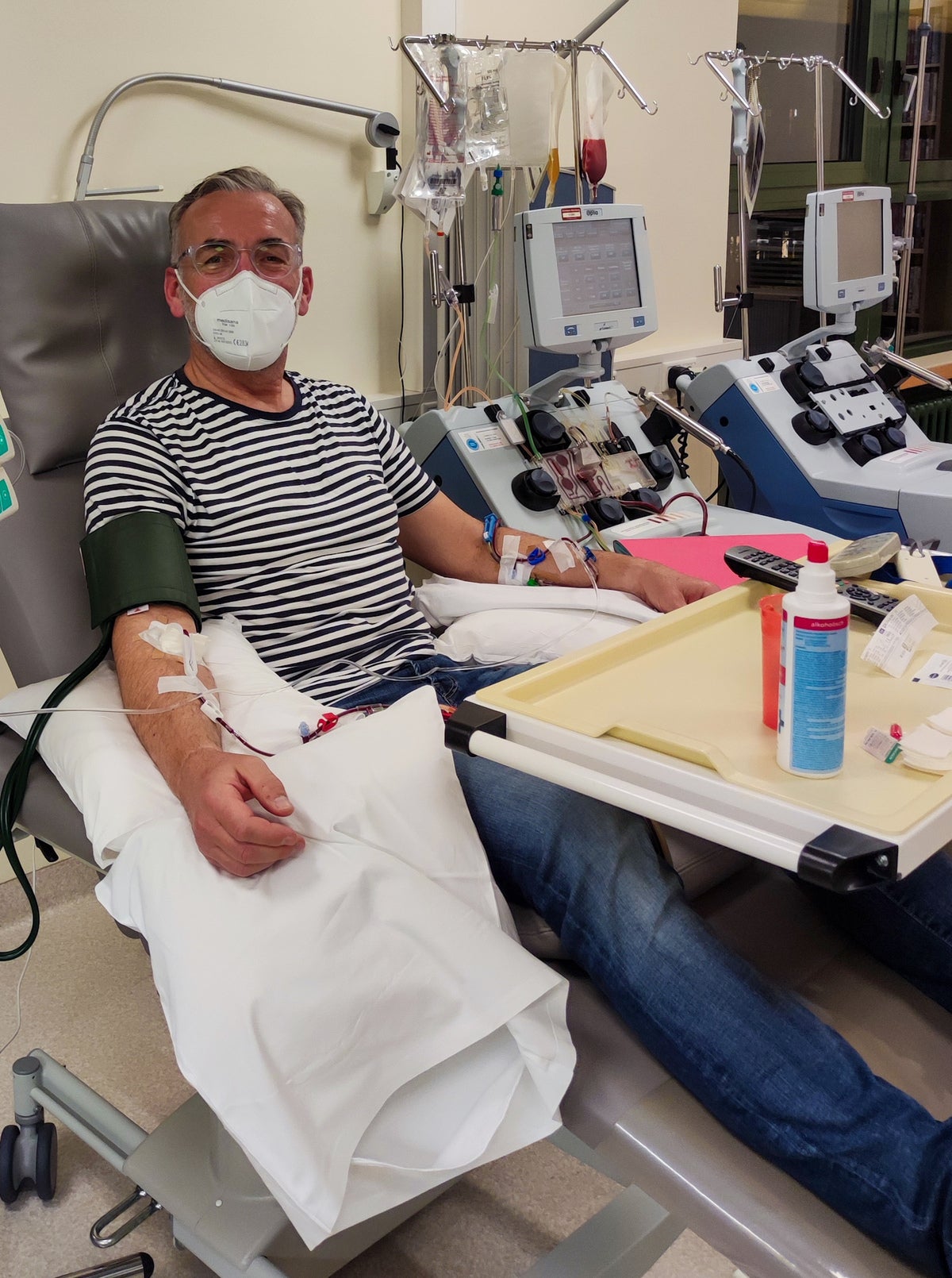 Ein Mann während seiner Stammzellspende, er trägt eine Maske 