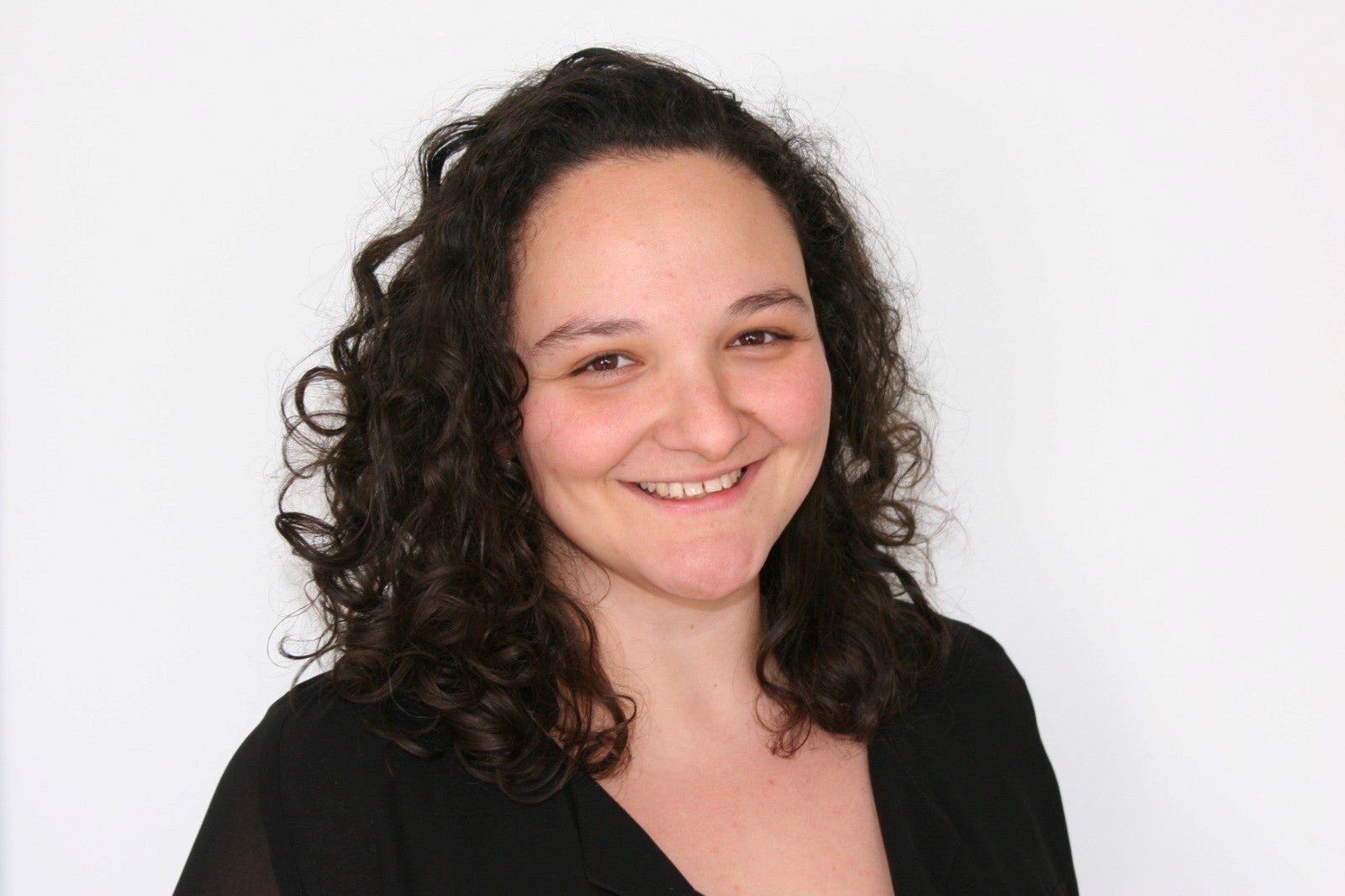 Eine Frau mit lockigem Haar lächelt