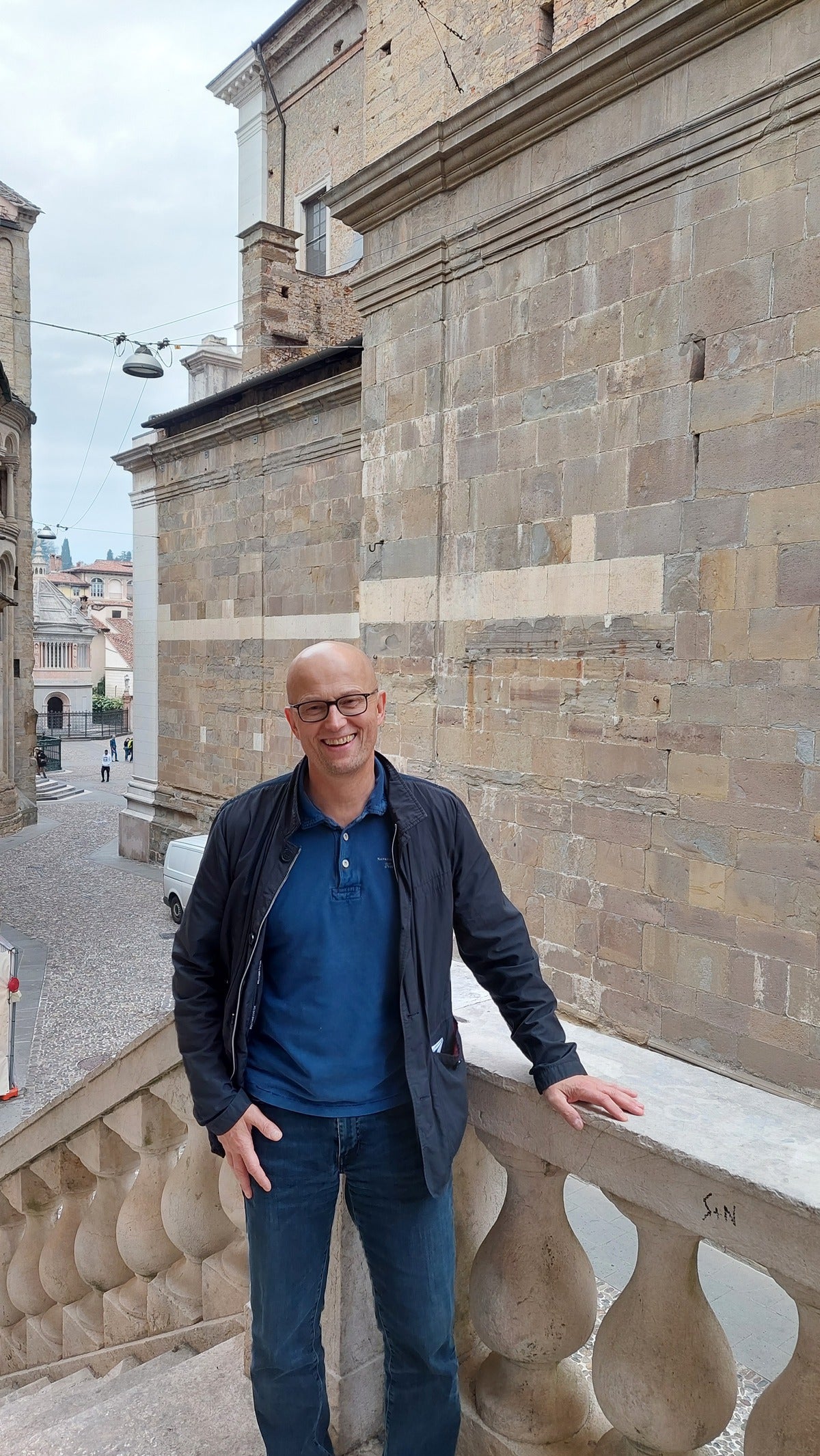ein Mann mit Glatze posiert für ein Foto auf einer Treppe