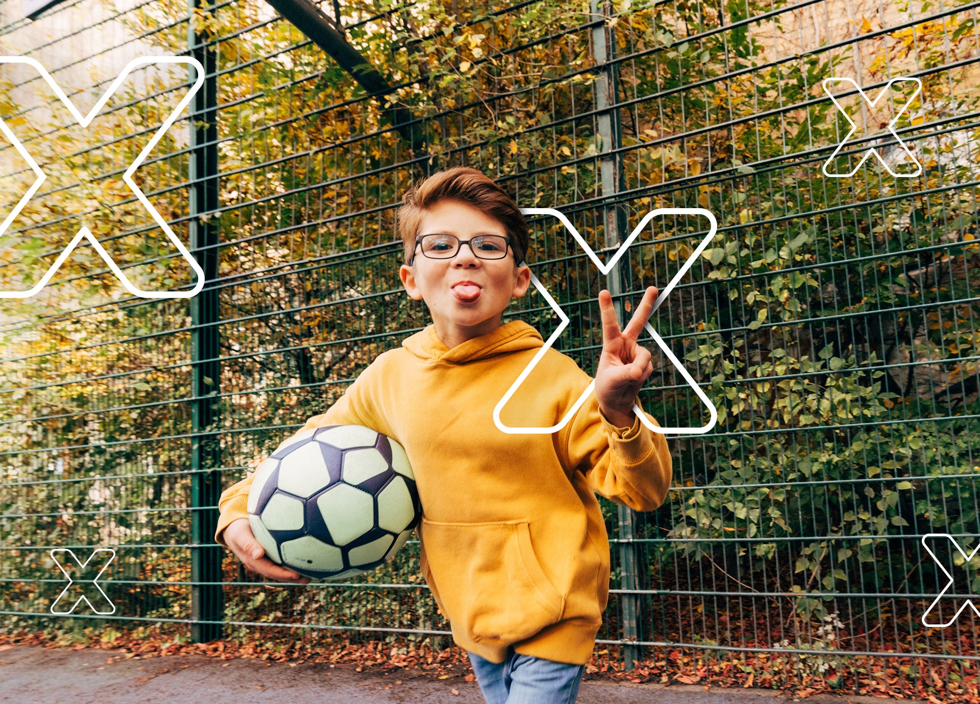 Ein Junge, der einen Fußball hält und seine Zunge herausstreckt