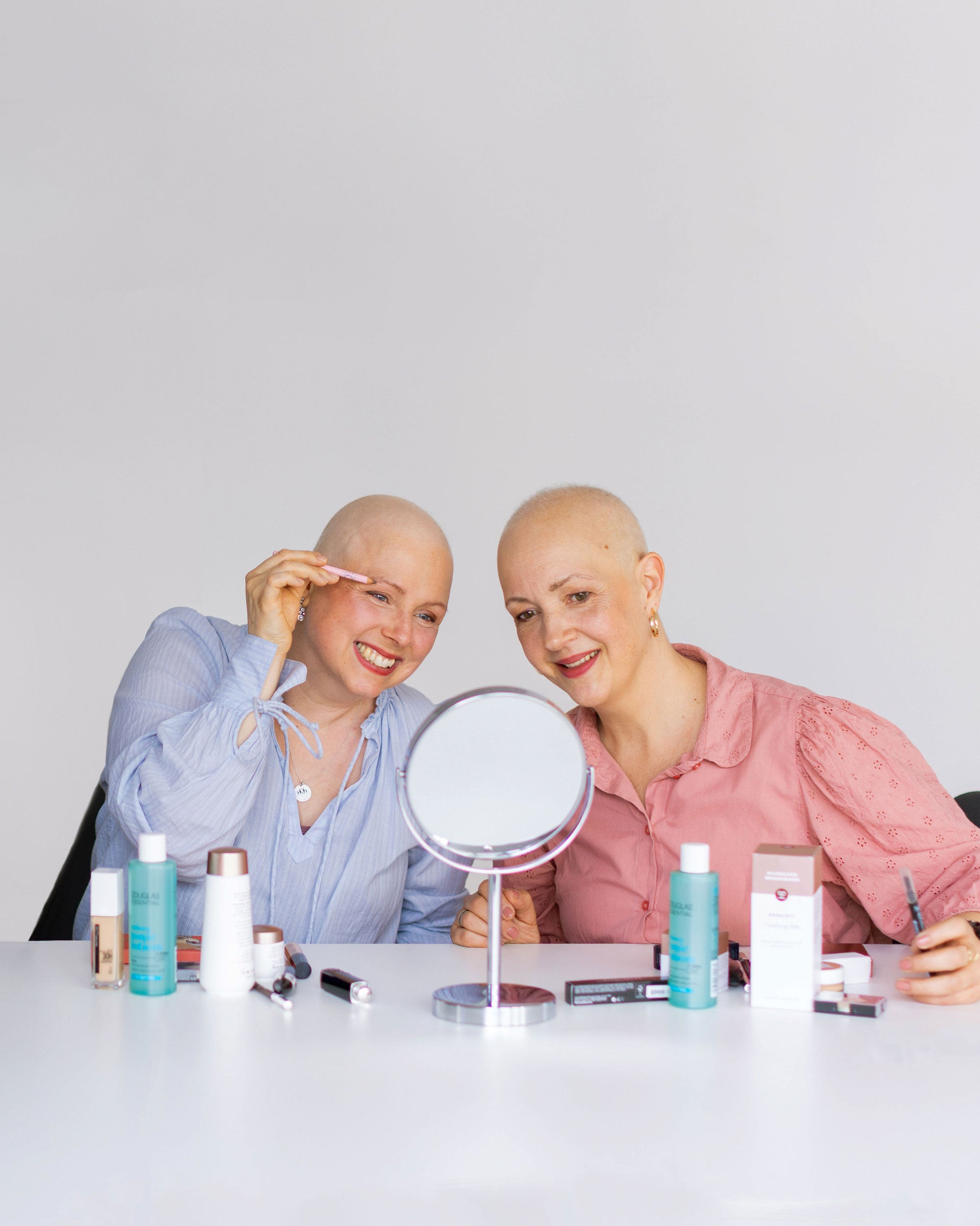 Zwei krebskranke Frauen beim look good feel better Seminar mit Kosmetik in der Hand