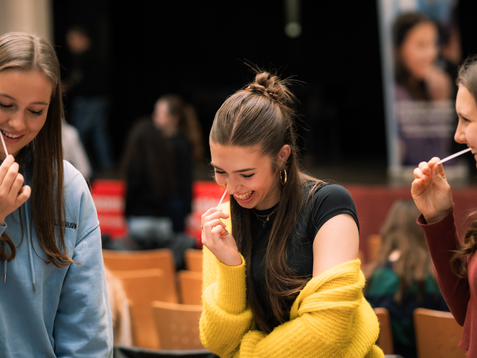 Drei Schülerinnen machen bei einer Schulaktion einen Wangenabstrich