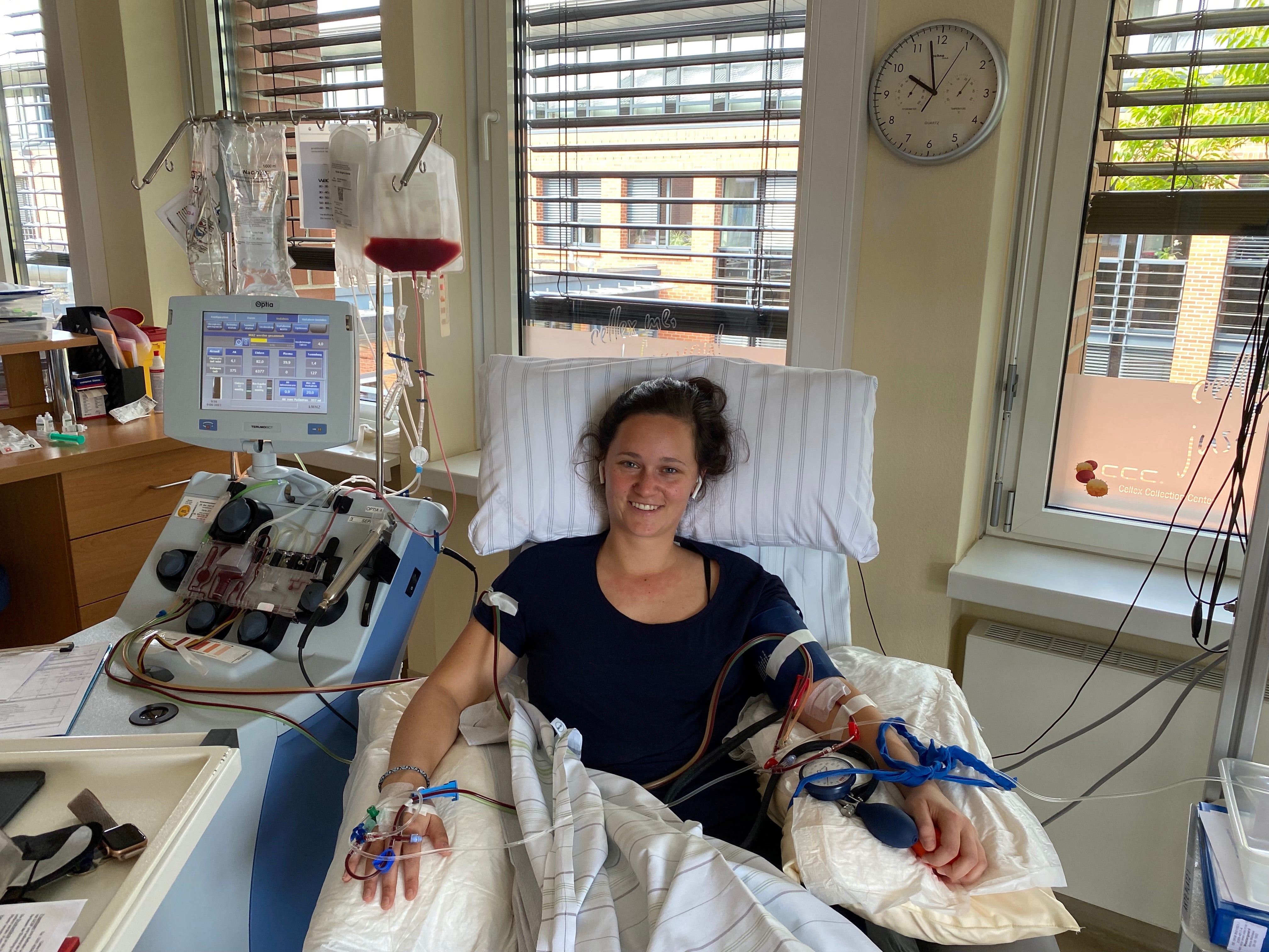 Eine Frau liegt während ihrer Stammzellspende in einem Bett, sie ist an ein Apherese-Gerät angeschlossen
