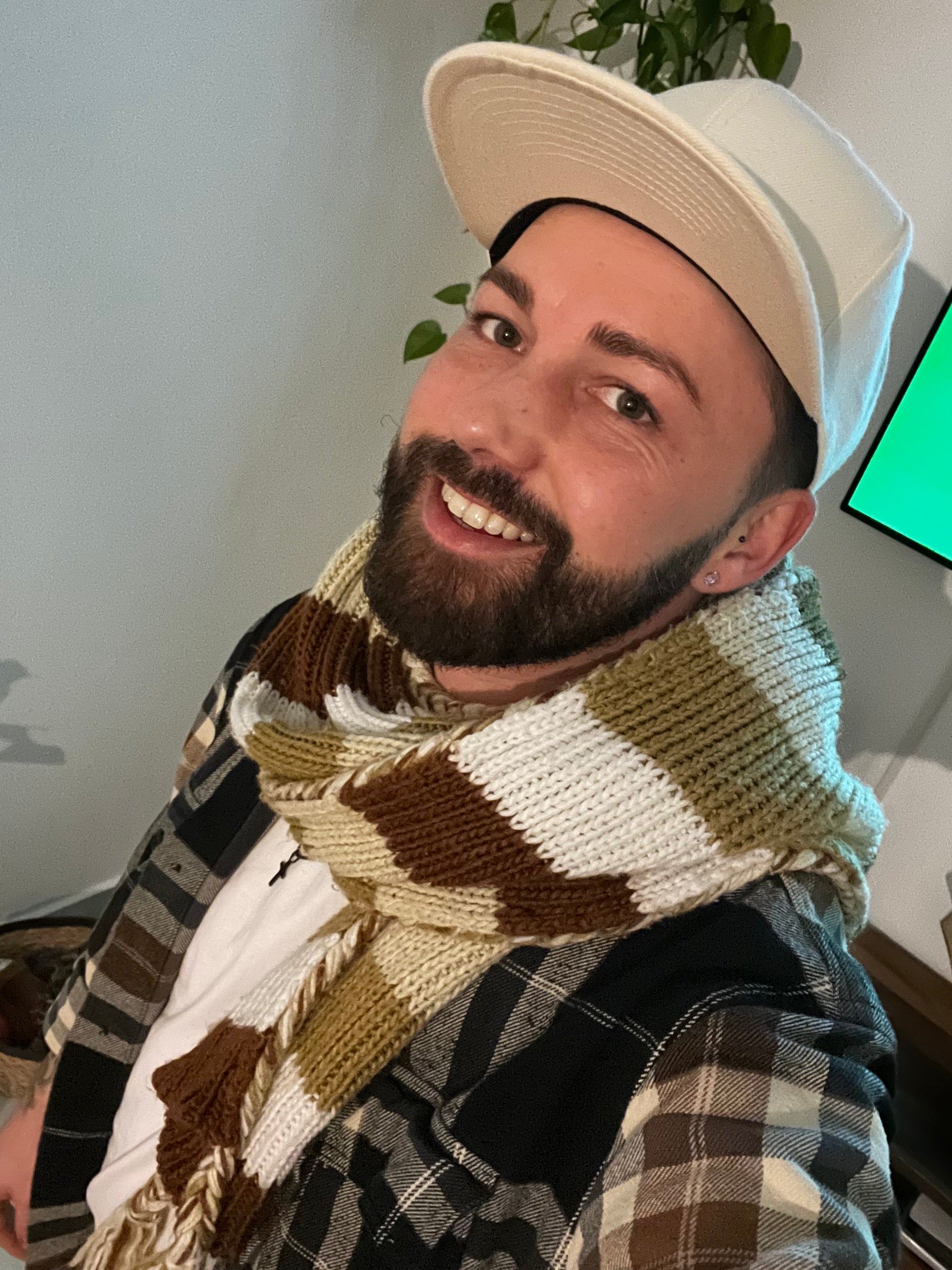 Ein Mann mit Hut lächelt in die Kamera.