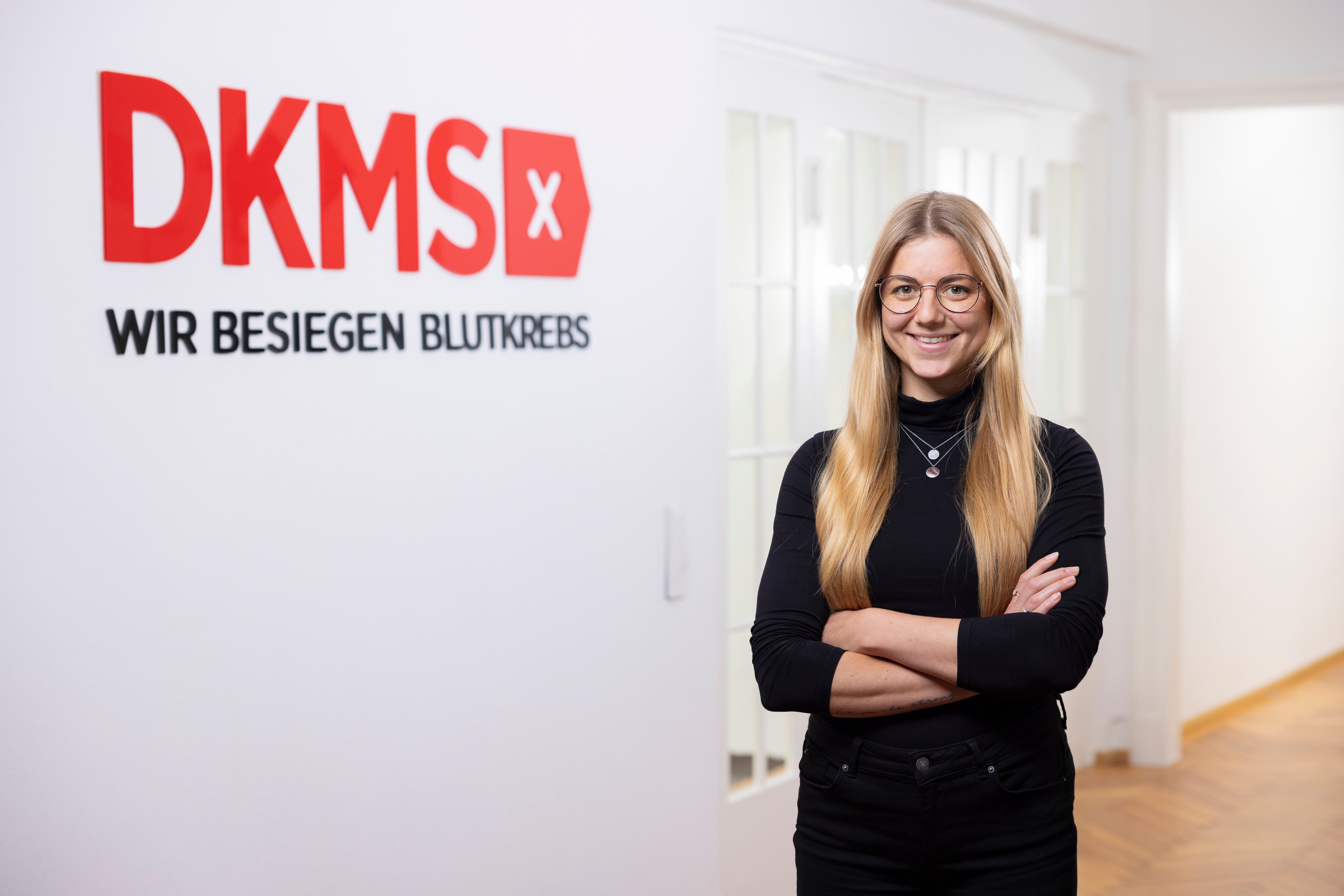 Judith Bittner vor dem DKMS Logo