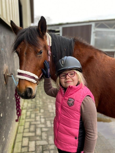 Ein Mädchen streichelt ein Pferd