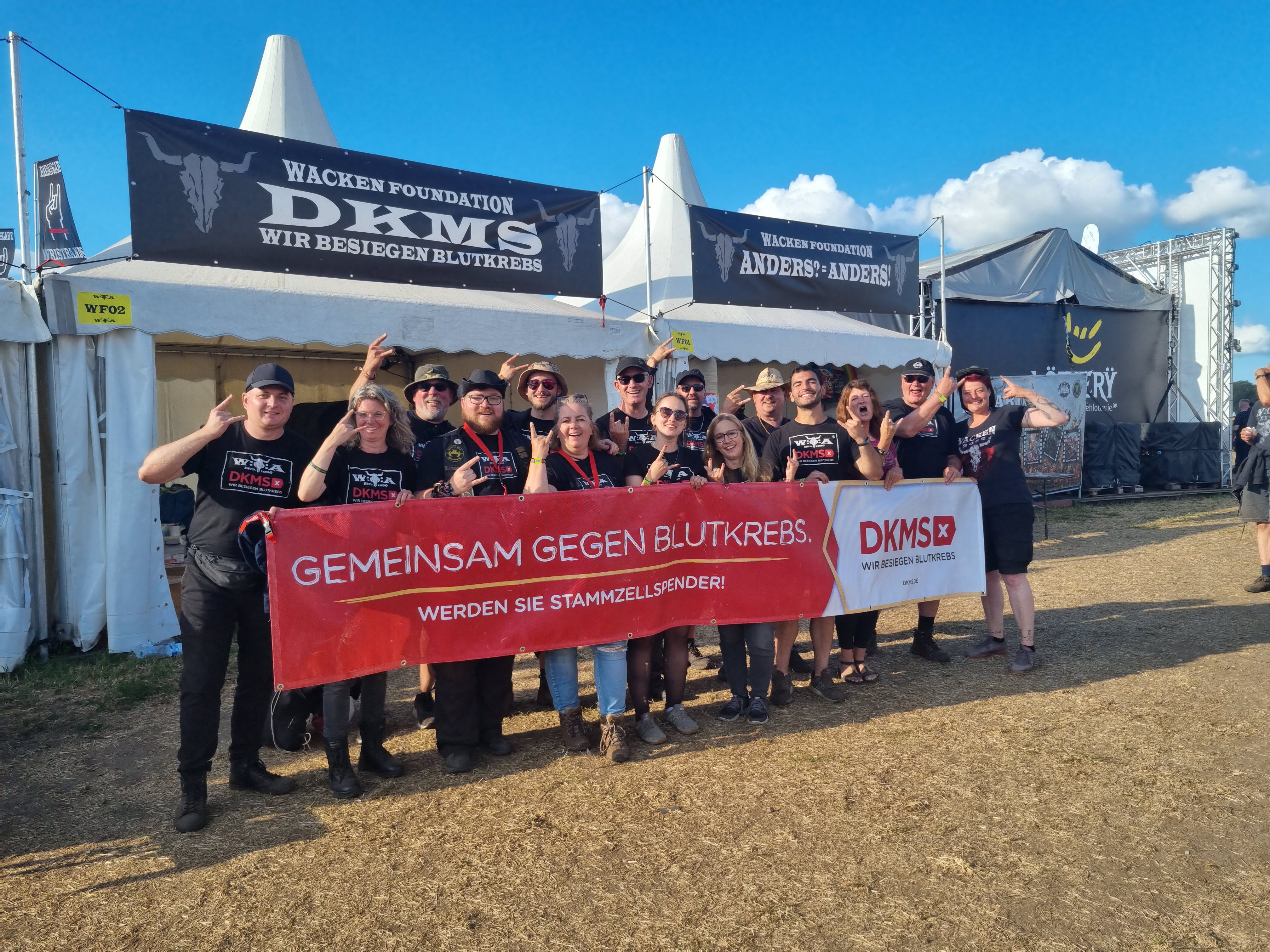 Eine Gruppe von Menschen posiert für ein Foto, sie halten ein Banner mit der Aufrschift: Gemeinsam gegen Blutkrebs