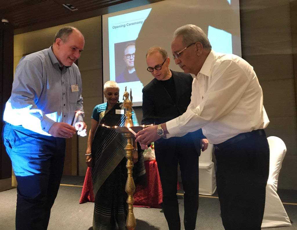 Eine Gruppe von Menschen steht um eine Öllampe herum