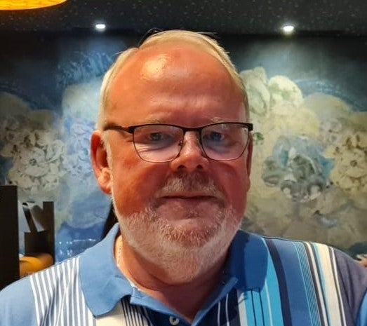 Ein Mann mit Brille schaut in die Kamera. 