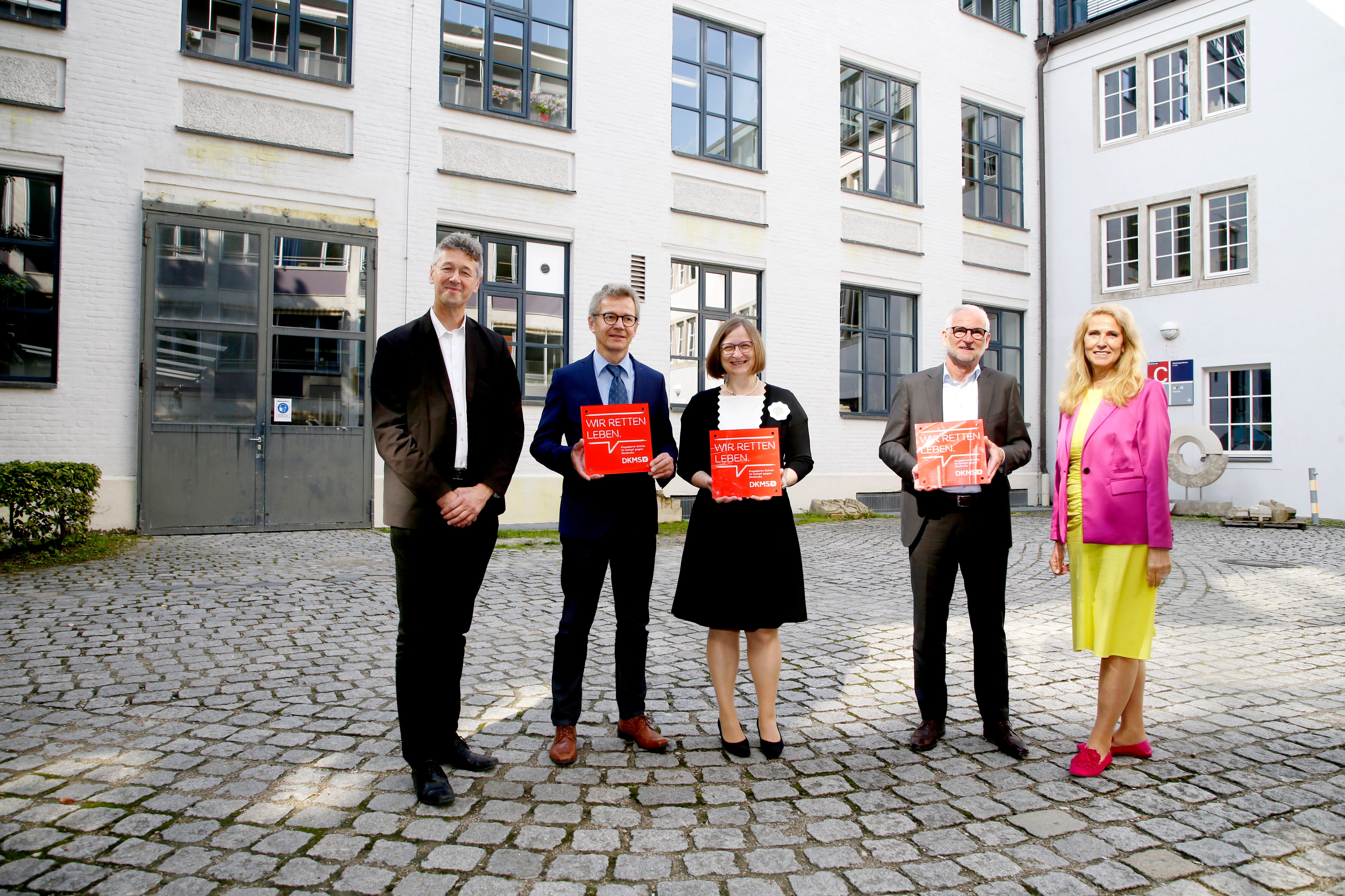 DKMS Geschäftsführerin Dr. Elke Neujahr, der Bayerische Staatsminister für Unterricht und Kultus, Prof. Dr. Michael Piazolo mit den Schulleiter:innen der drei ausgezeichneten Schulen Gerhard Kilian, Robert Predasch und Hermine Scroggie