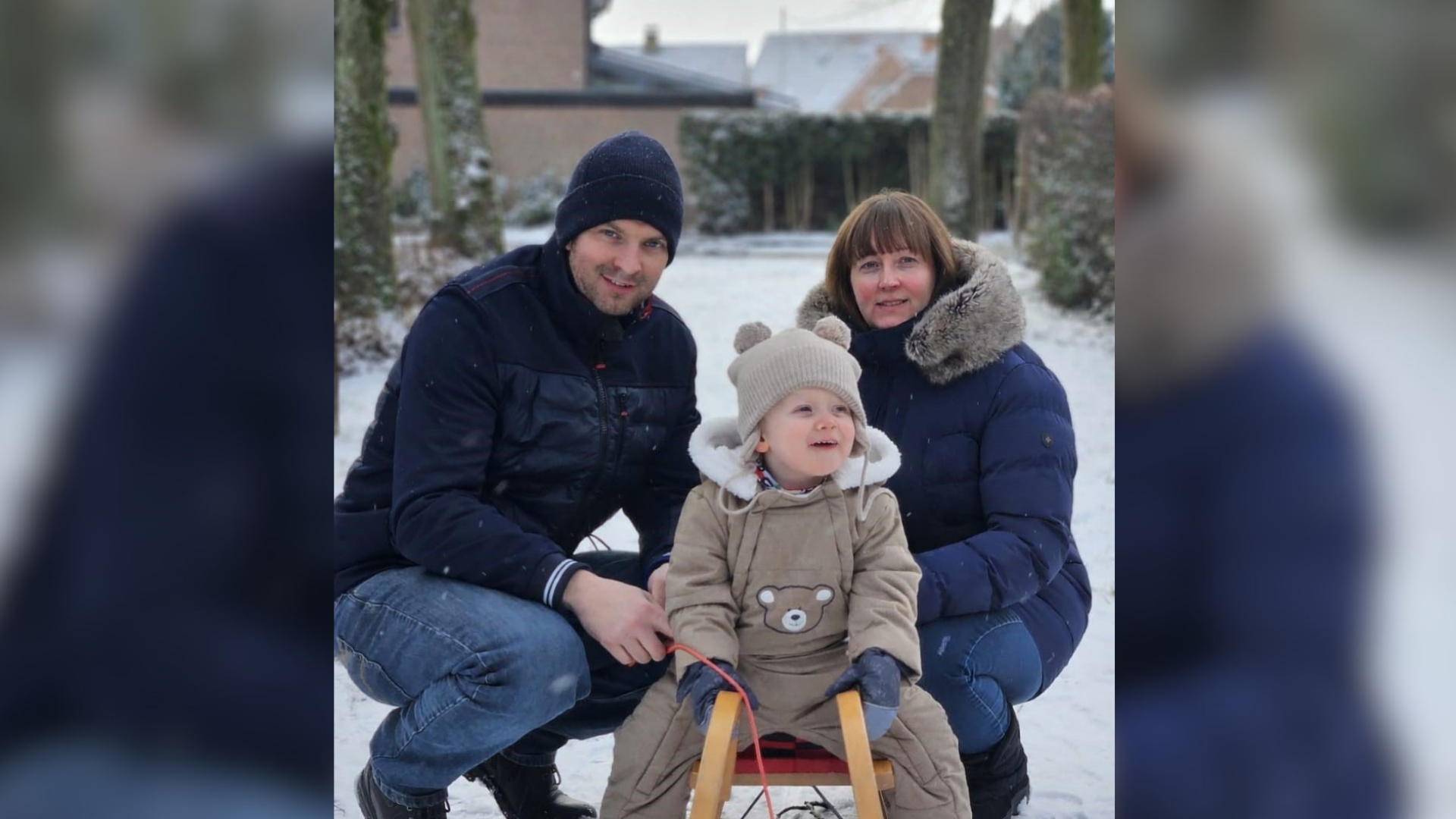 Ein Mann und eine Frau mit einem Kind auf einem Schlitten im Schnee
