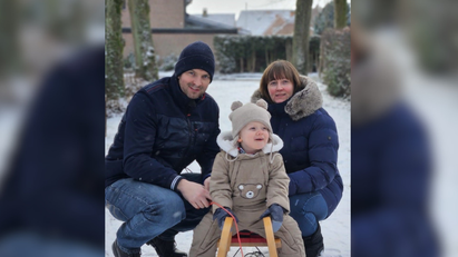 Ein Mann und eine Frau mit einem Kind auf einem Schlitten im Schnee