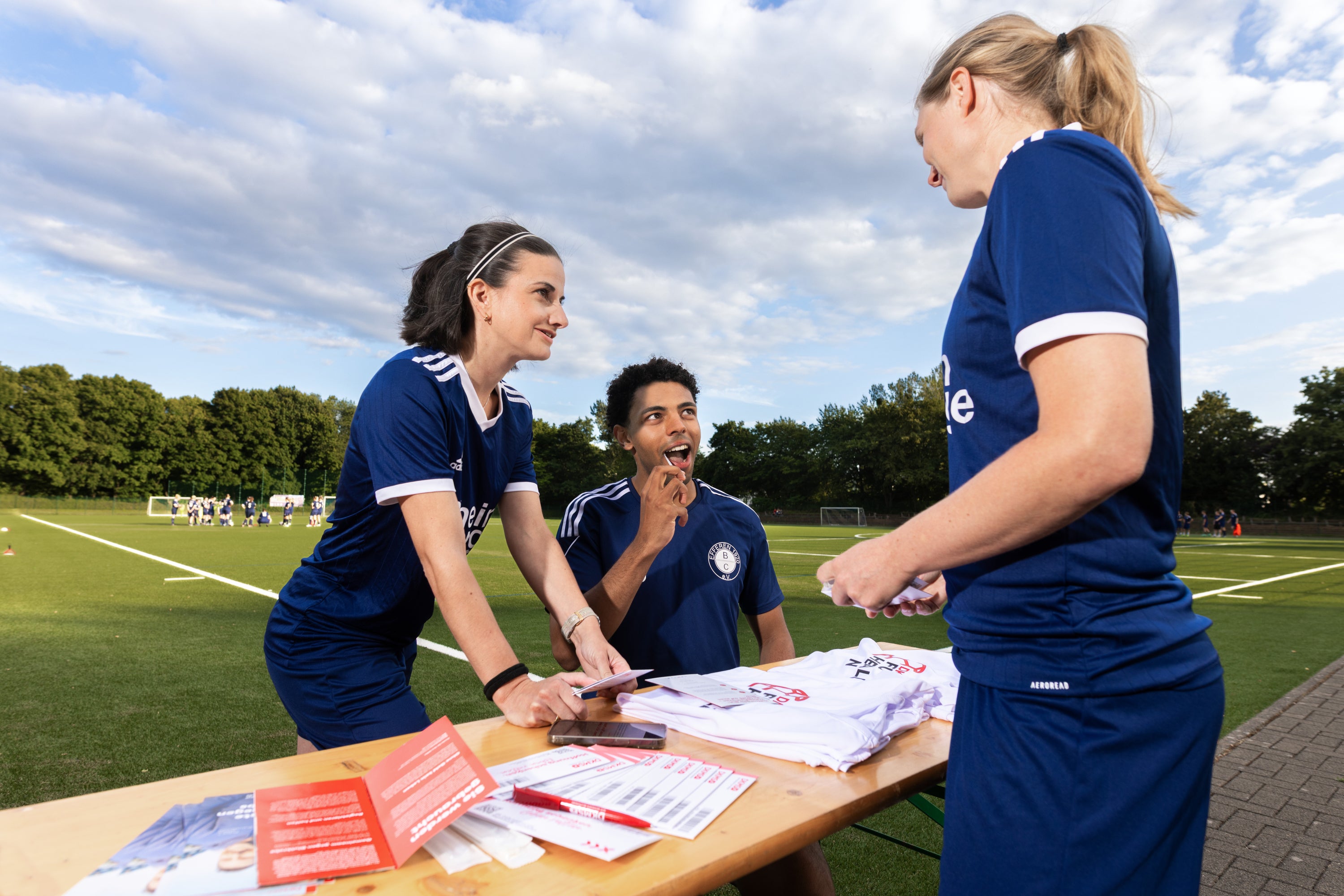 Eine Gruppe von Menschen, die um einen Tisch herum stehen