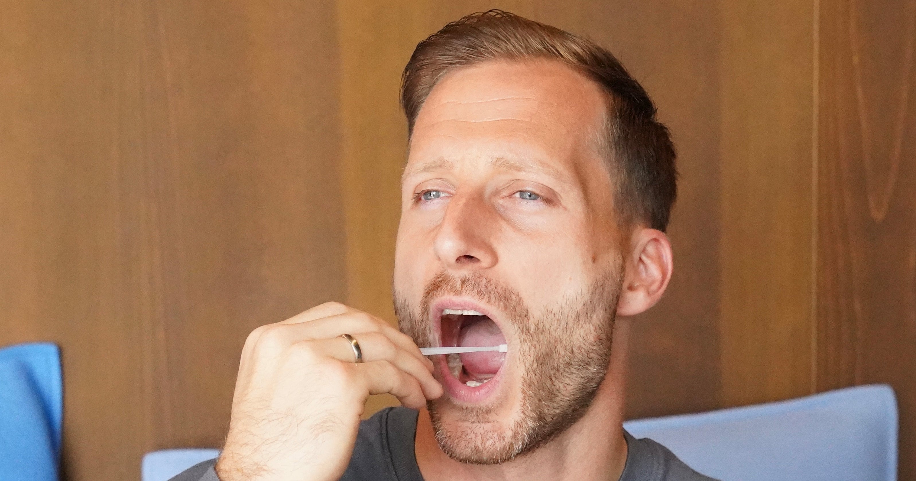 Ein Mann mit einem Wattestäbchen im Mund