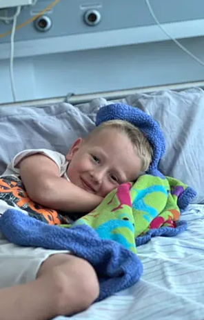 Luis der auf einer Kuscheldecke im Bett liegt. 