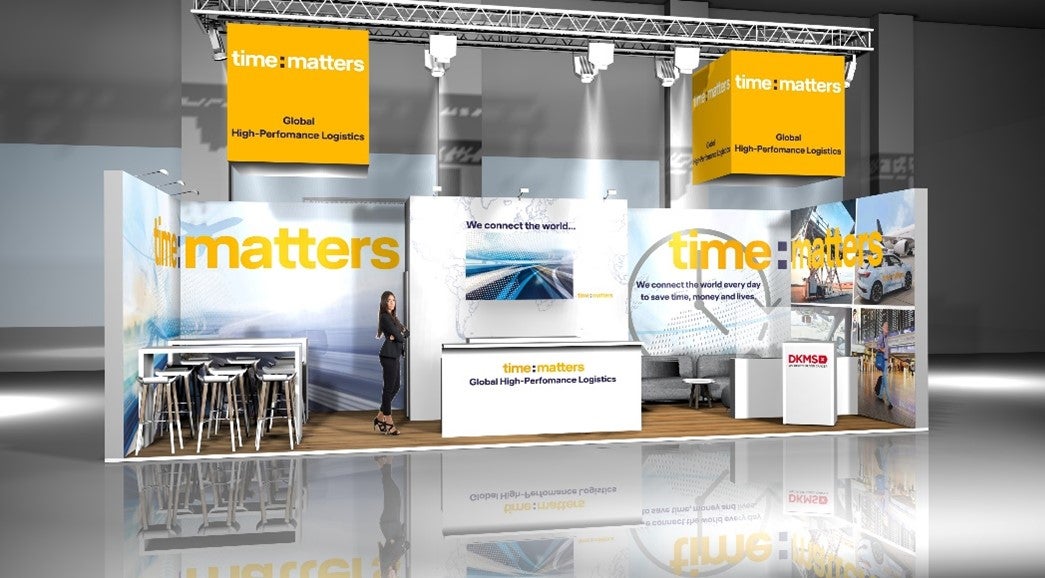 Ein Messestand mit einer Frau, die auf der Fläche steht.